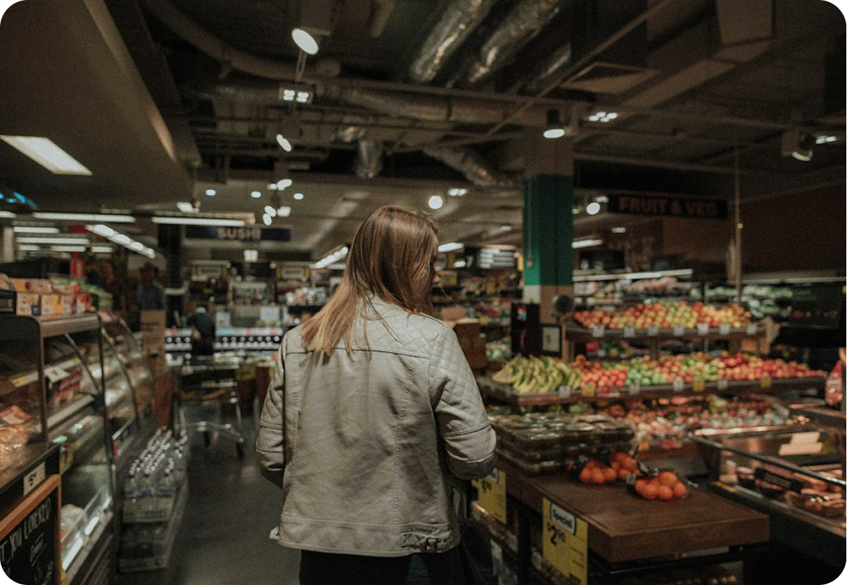 Interior de un supermercado con góndolas de frutas y verduras